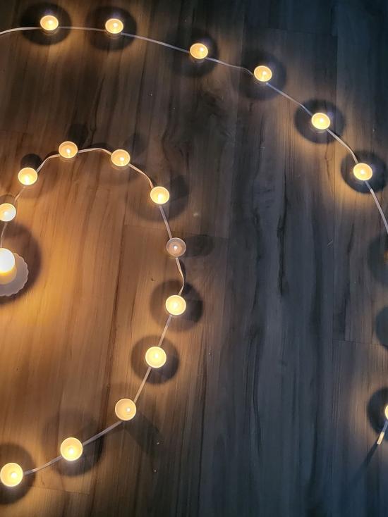 Lichterspirale mit Teelichtern in der Dunkelheit