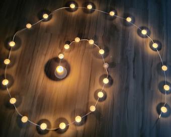 Lichterspirale mit Teelichtern in der Dunkelheit